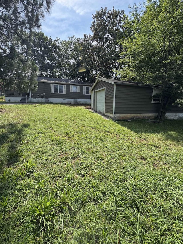  - view of grassy yard featuring a garage and an outdoor structure