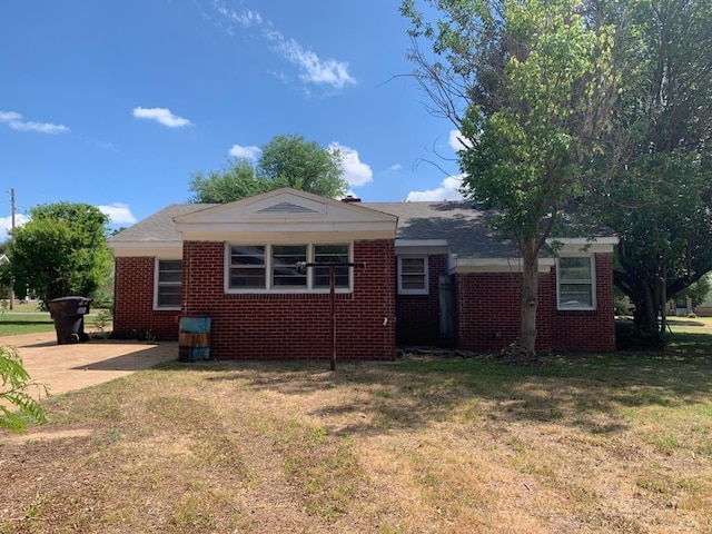 view of side of property featuring a yard and brick siding