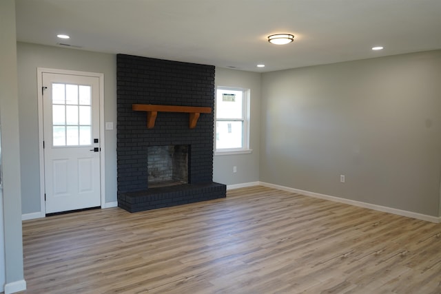 unfurnished living room featuring a fireplace and light wood-type flooring