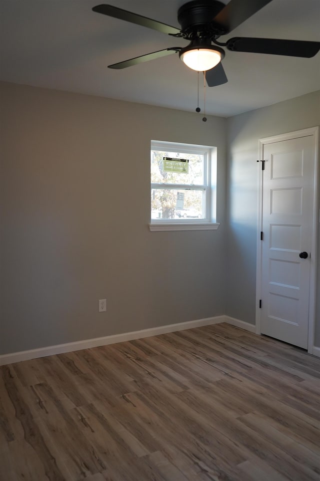 spare room featuring ceiling fan and dark wood-type flooring