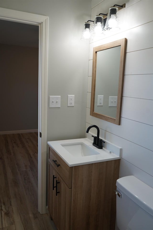 bathroom featuring wood-type flooring, vanity, and toilet