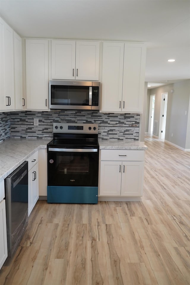 kitchen featuring light stone counters, white cabinetry, and stainless steel appliances