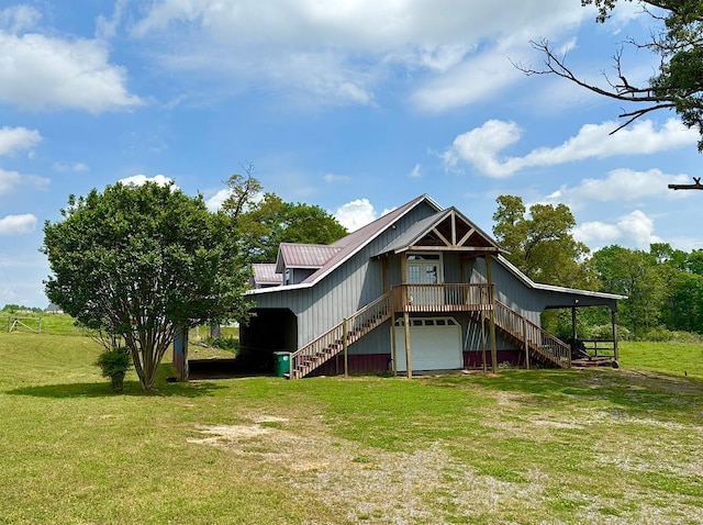  - rear view of property featuring stairway, dirt driveway, a yard, and an attached garage