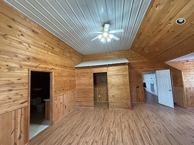  - unfurnished living room featuring wooden ceiling, wooden walls, lofted ceiling, wood finished floors, and ceiling fan