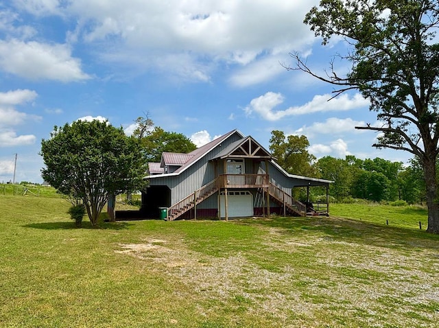  - rear view of house with stairway, a lawn, a garage, and a metal roof