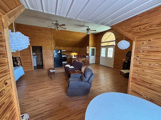 - living room with wood finished floors, wooden walls, french doors, and ceiling fan
