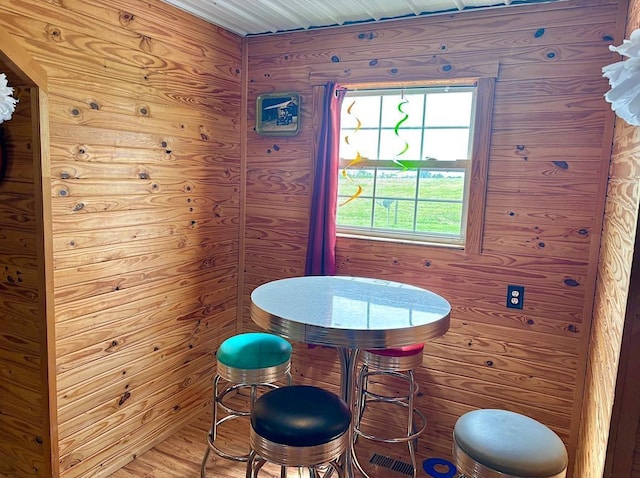  - dining space with wood walls and wood finished floors
