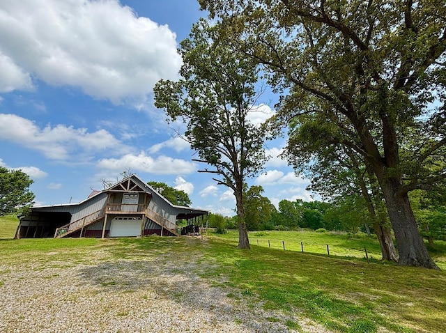  - view of yard featuring stairway and driveway