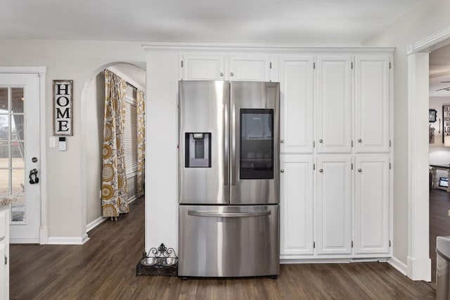 kitchen featuring arched walkways, dark wood-style flooring, stainless steel refrigerator with ice dispenser, white cabinets, and baseboards