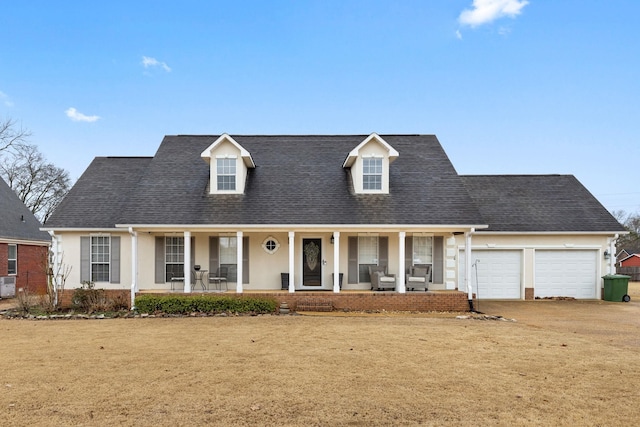 cape cod house with a shingled roof, stucco siding, an attached garage, covered porch, and brick siding