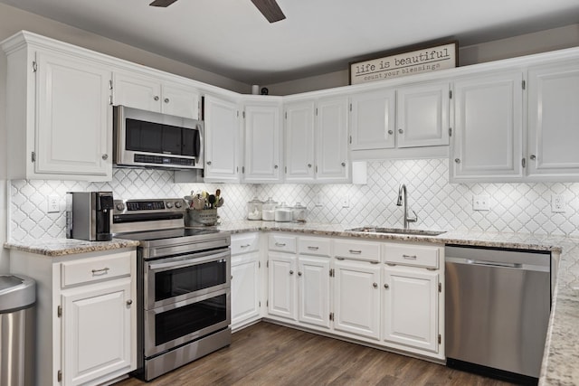 kitchen featuring dark wood finished floors, stainless steel appliances, white cabinets, a sink, and ceiling fan