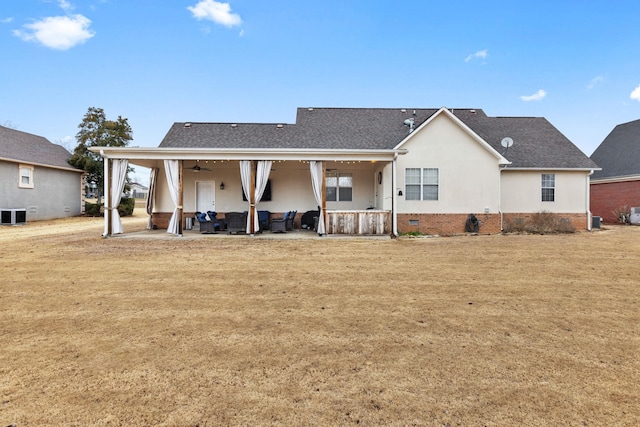 back of house featuring crawl space, a patio area, a lawn, and stucco siding