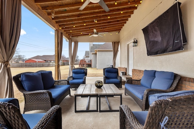 view of patio / terrace with ceiling fan, fence, and an outdoor living space