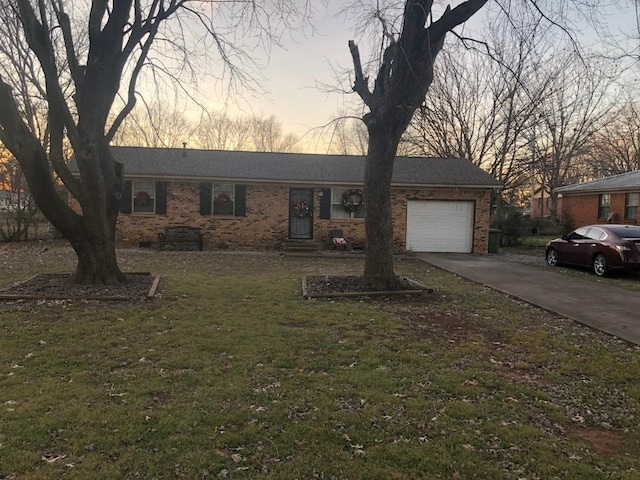 ranch-style home with a garage and a lawn