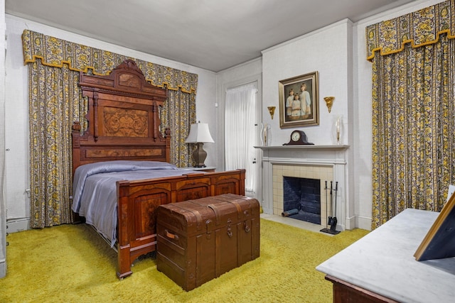 bedroom with a tile fireplace, light carpet, and baseboard heating