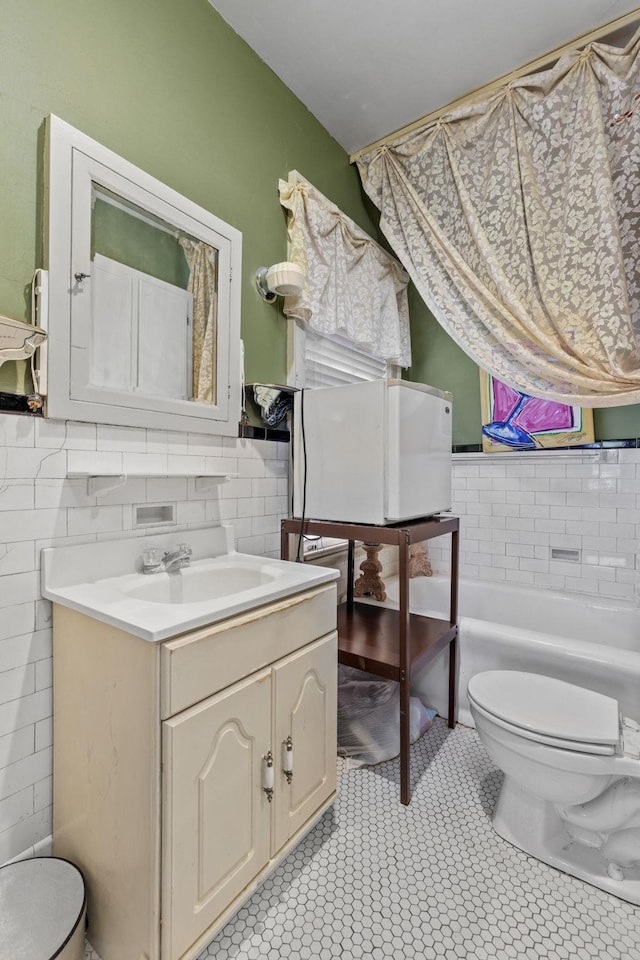 bathroom featuring a washtub, vanity, and toilet