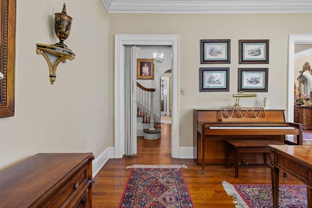 misc room featuring dark hardwood / wood-style flooring, an inviting chandelier, and ornamental molding