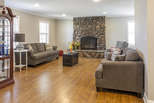  - living room featuring a stone fireplace, recessed lighting, crown molding, and wood-type flooring