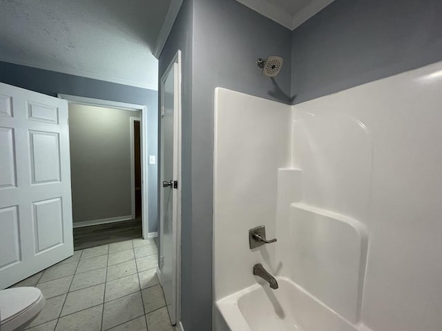 bathroom with tile patterned floors, toilet, a textured ceiling, shower / bathtub combination, and ornamental molding