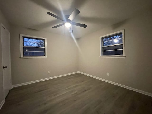 spare room with dark wood-type flooring and ceiling fan