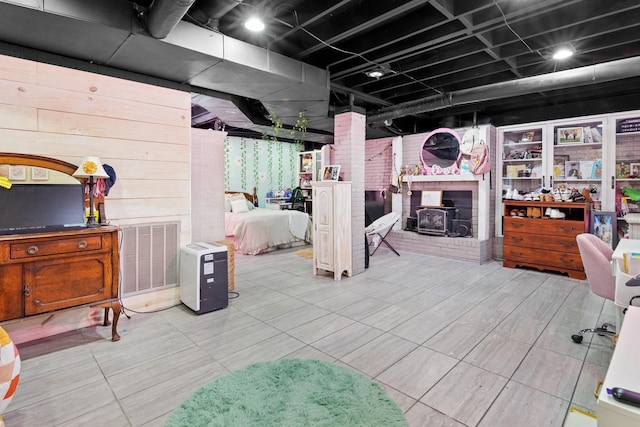 basement with wood walls and a wood stove