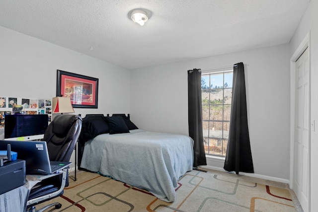 carpeted bedroom featuring a textured ceiling