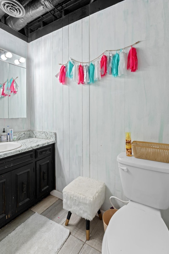 bathroom featuring toilet, vanity, and hardwood / wood-style floors