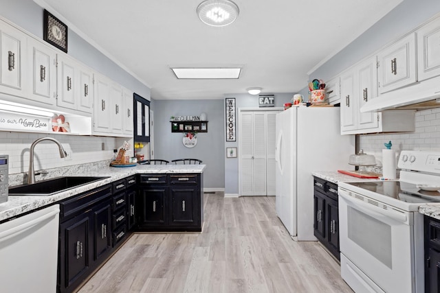 kitchen with tasteful backsplash, sink, white appliances, and white cabinetry