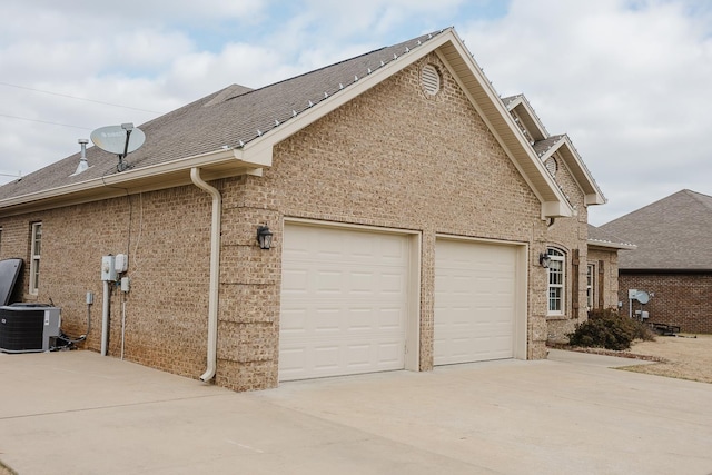 view of side of home with cooling unit and a garage