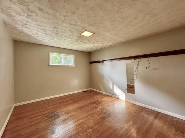  - empty room featuring wood finished floors and a textured ceiling