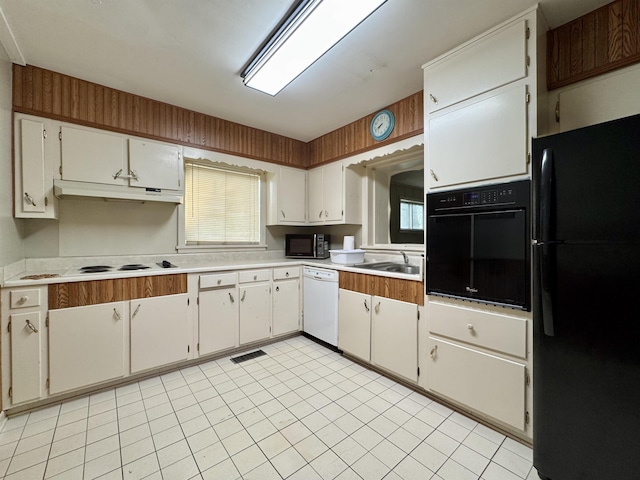  - kitchen featuring black appliances, under cabinet range hood, light countertops, light tile patterned floors, and white cabinets