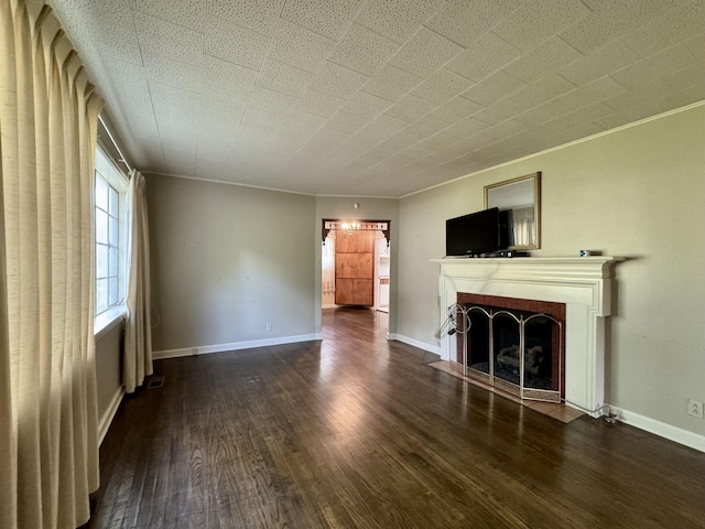  - unfurnished living room with a fireplace with flush hearth, wood finished floors, and crown molding