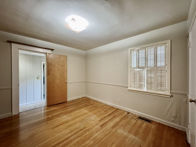  - empty room featuring wood finished floors and baseboards