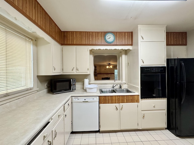  - kitchen featuring black appliances, light countertops, white cabinetry, and light tile patterned flooring