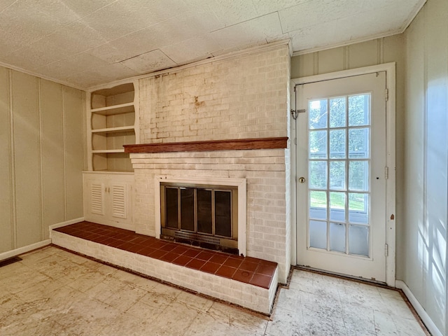  - unfurnished living room with healthy amount of natural light, a brick fireplace, and built in shelves