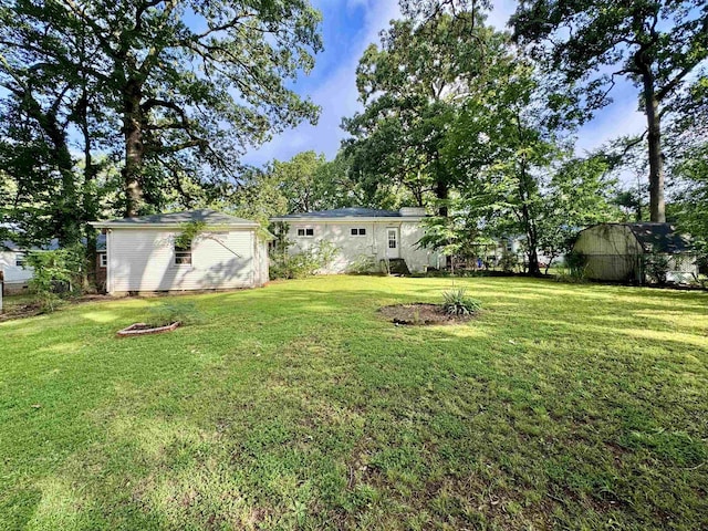  - view of green lawn with an outbuilding
