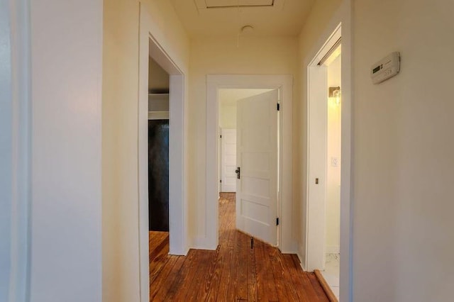  - hall featuring attic access and dark wood-type flooring