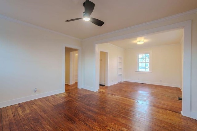  - empty room featuring hardwood / wood-style floors, a ceiling fan, built in shelves, and crown molding