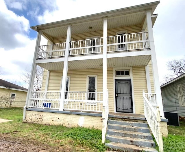 view of front of house with a balcony and covered porch