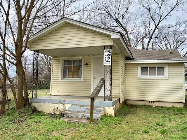 view of front of house with a front lawn, roof with shingles, and crawl space