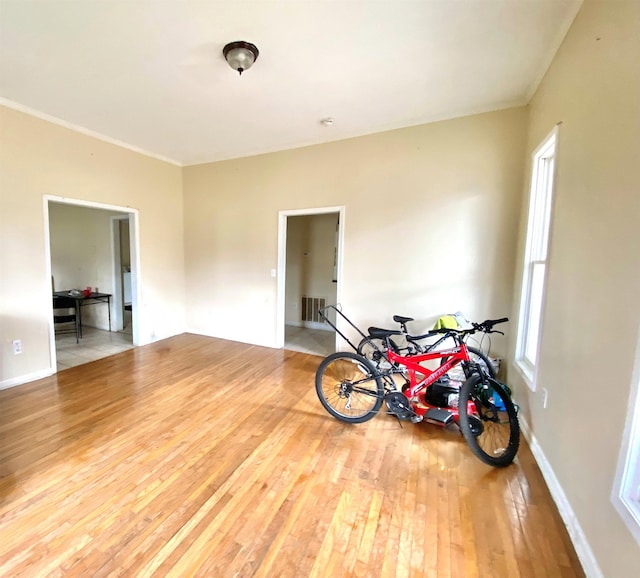 spare room featuring visible vents, baseboards, and wood-type flooring