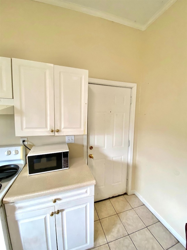 clothes washing area featuring light tile patterned floors, baseboards, and ornamental molding