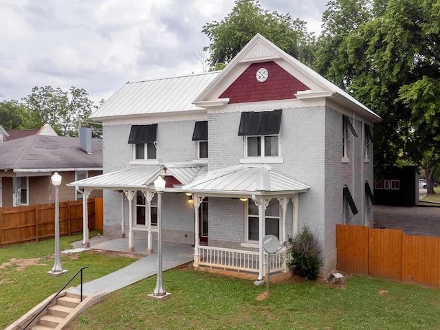  - view of front facade with brick siding, a porch, and a front yard