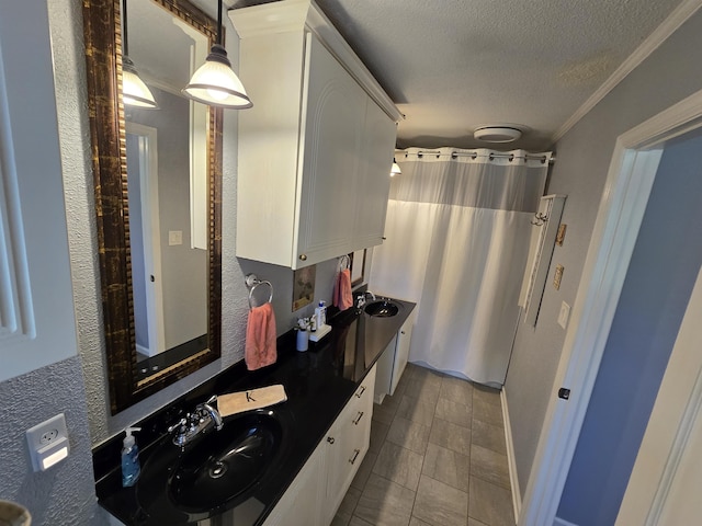  - bathroom with a textured ceiling, double vanity, a shower with curtain, tile patterned flooring, and ornamental molding