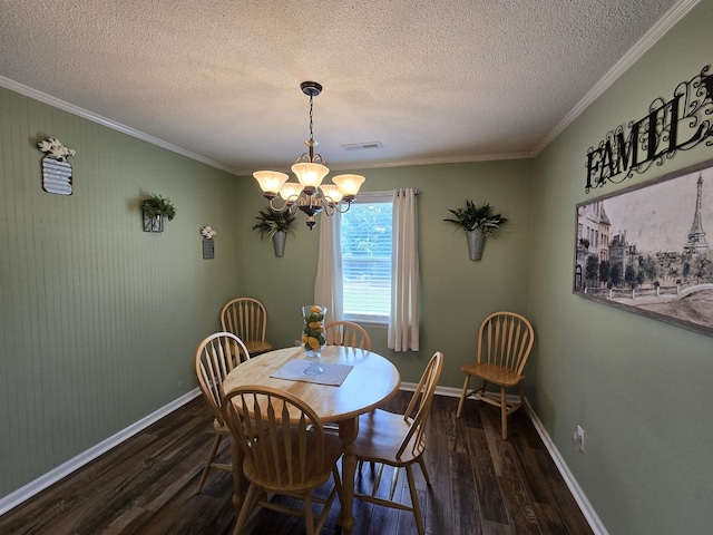  - dining room with dark wood-style flooring, a textured ceiling, ornamental molding, and a chandelier