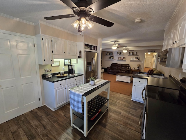  - kitchen featuring stainless steel appliances, a ceiling fan, dark countertops, white cabinetry, and a textured ceiling