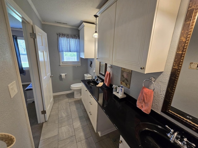  - full bath featuring double vanity, crown molding, a textured ceiling, and a textured wall