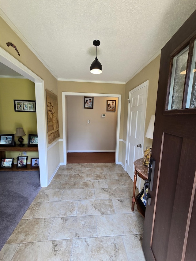  - foyer with ornamental molding, a textured ceiling, and light stone finish flooring