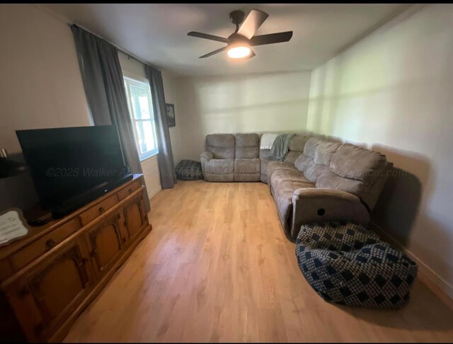  - living area with light wood-type flooring and ceiling fan