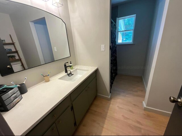  - full bath featuring wood finished floors, vanity, and a shower with shower curtain